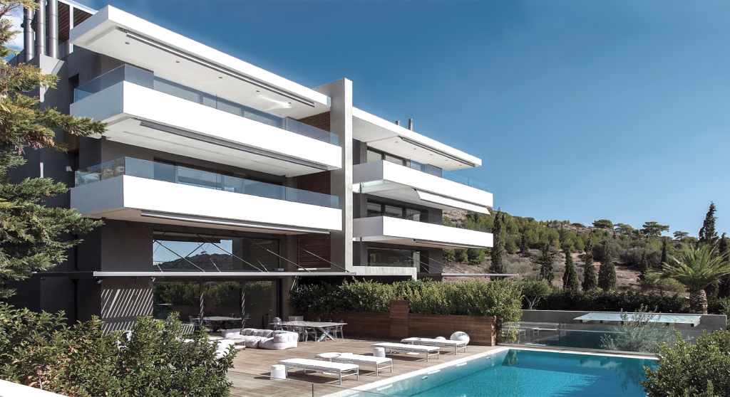 residential complex with large balconies and designated exterior space with sofas and tables near the pool