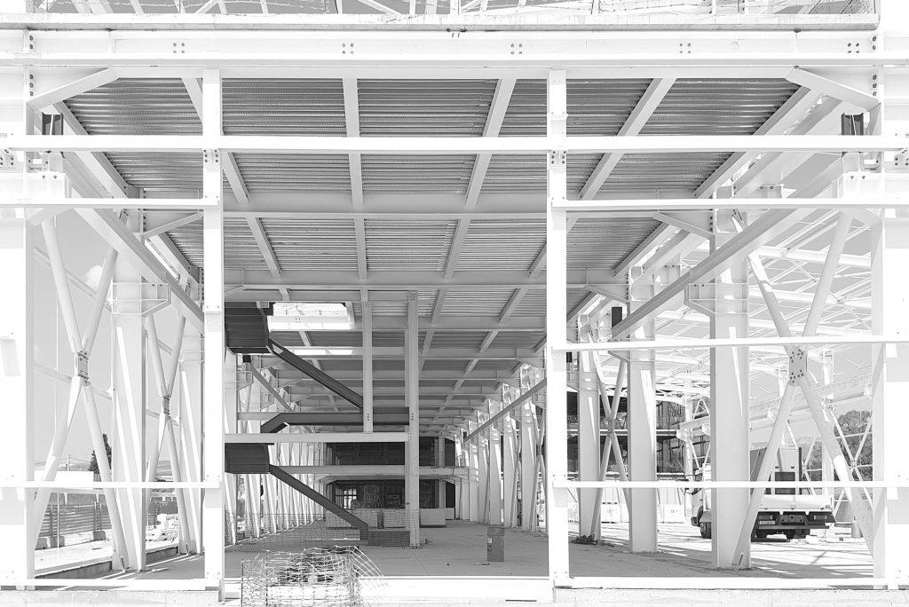 black and white photograph of an industrial building frame with exposed ironwork