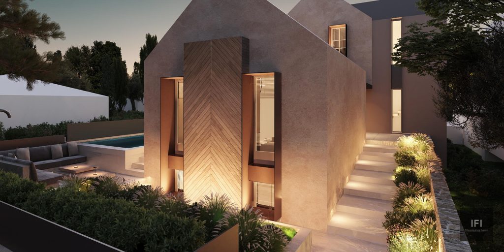 exterior image of a residence with exterior lights and stone fence