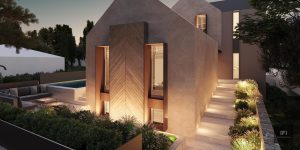 exterior image of a residence with exterior lights and stone fence